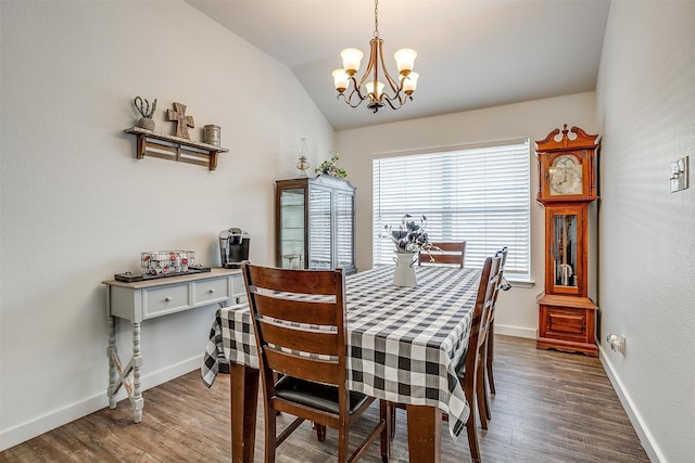 dining room with dark hardwood / wood-style flooring, a chandelier, and lofted ceiling