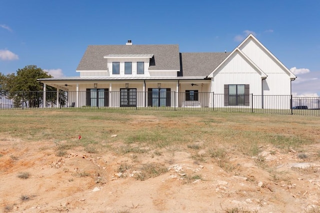 rear view of property with a shingled roof, metal roof, a standing seam roof, and fence