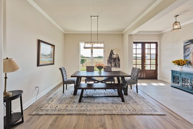 dining area with a wealth of natural light, french doors, crown molding, and wood finished floors