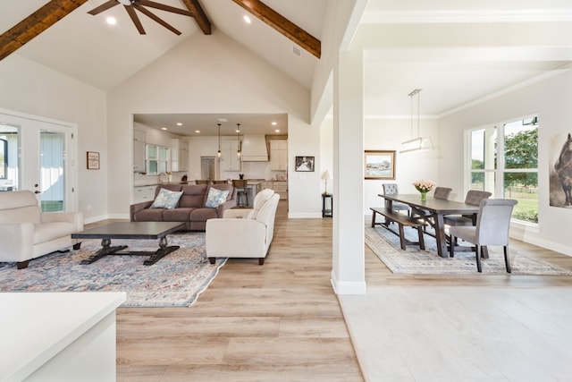 living room with high vaulted ceiling, beamed ceiling, crown molding, ceiling fan, and light hardwood / wood-style flooring