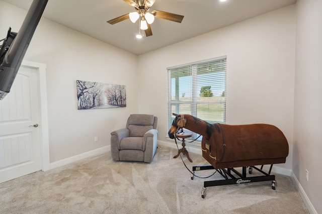 living area with ceiling fan and light colored carpet