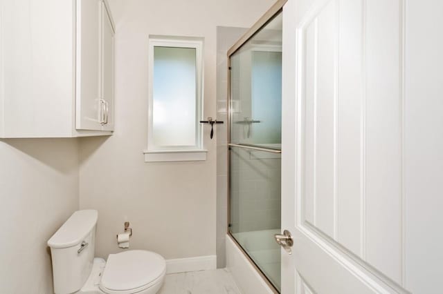 full bath with baseboards, toilet, marble finish floor, and shower / bath combination with glass door