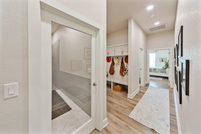 corridor with light hardwood / wood-style floors