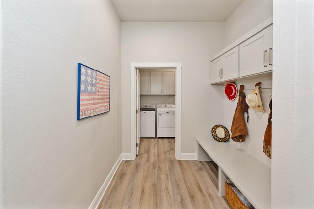 mudroom featuring washing machine and clothes dryer, light wood finished floors, and baseboards