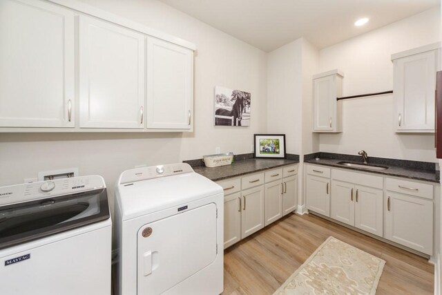 laundry room with light wood finished floors, washing machine and dryer, recessed lighting, cabinet space, and a sink