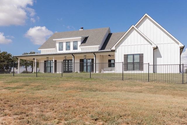 rear view of property featuring fence private yard, a lawn, board and batten siding, and a shingled roof