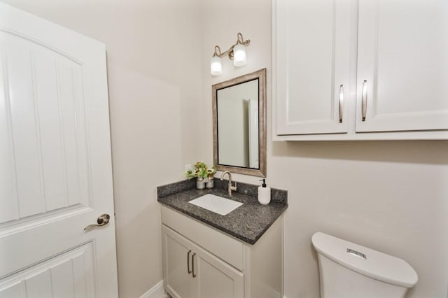 half bathroom featuring toilet and vanity