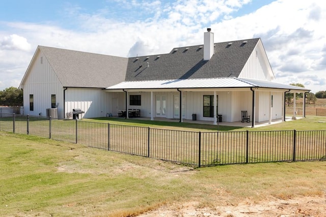 back of house featuring board and batten siding, fence, roof with shingles, a yard, and a patio