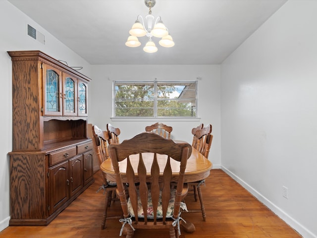 dining space featuring hardwood / wood-style floors and a notable chandelier