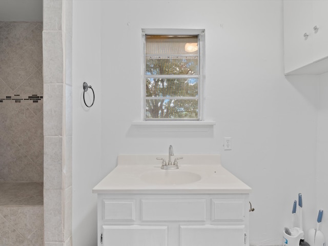 bathroom featuring a tile shower and vanity