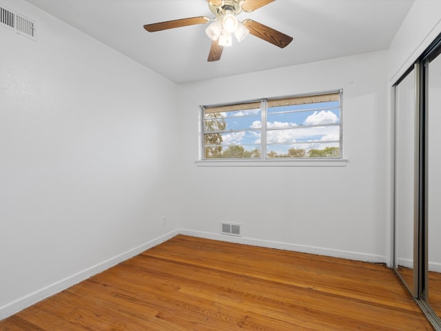 unfurnished bedroom with light hardwood / wood-style flooring, ceiling fan, and a closet