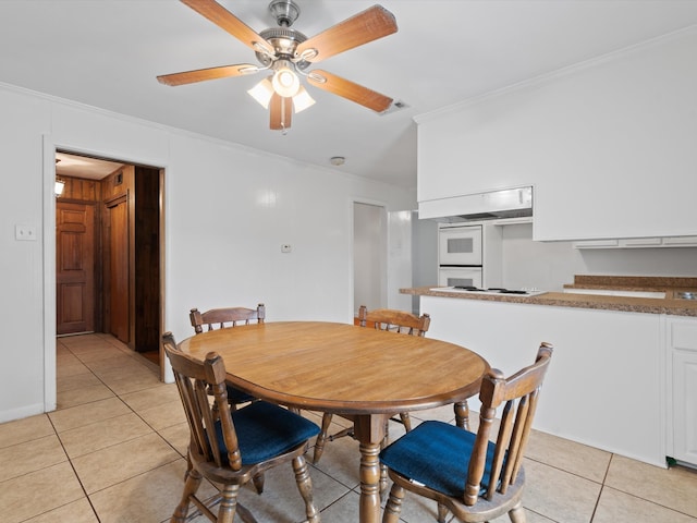 tiled dining room featuring ornamental molding and ceiling fan