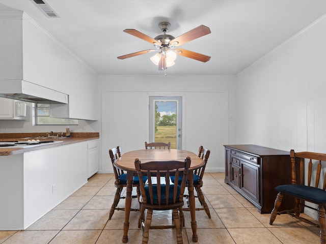 dining area with crown molding, light tile patterned flooring, and ceiling fan