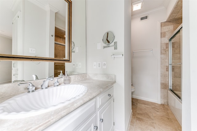 full bathroom featuring ornamental molding, vanity, toilet, and combined bath / shower with glass door