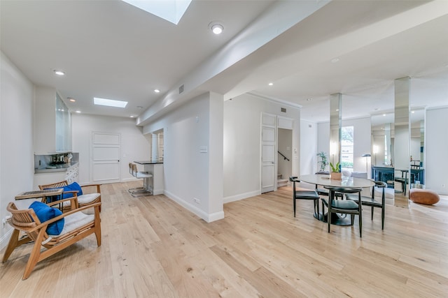 interior space featuring light wood-type flooring and a skylight