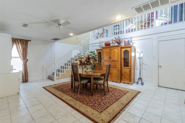 dining space with ceiling fan and a textured ceiling