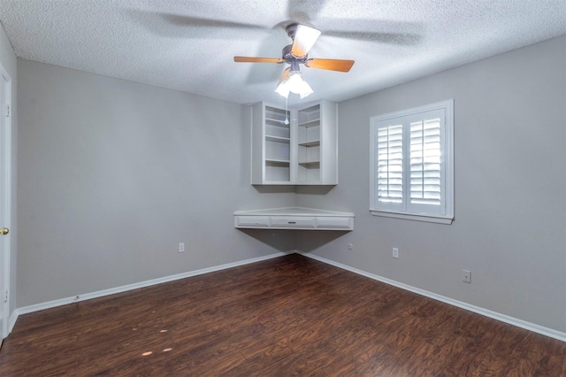 unfurnished office featuring ceiling fan, dark wood-type flooring, and a textured ceiling