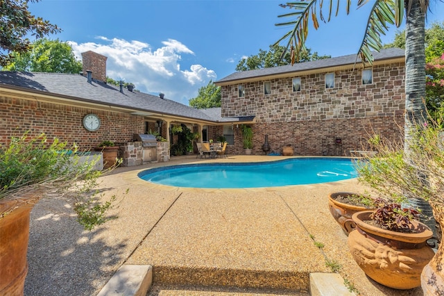 view of pool with area for grilling, a grill, and a patio area