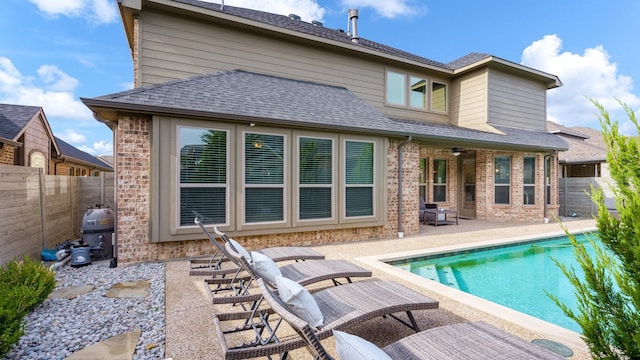 back of property featuring a patio area and a fenced in pool