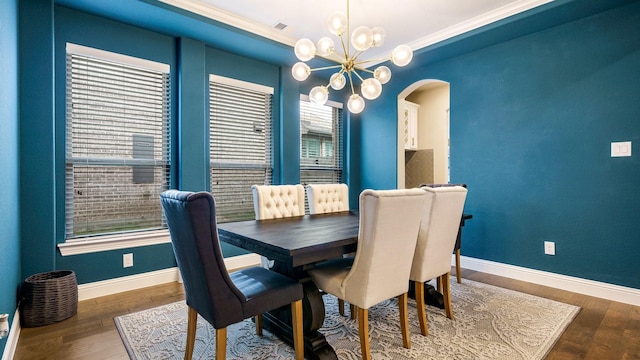 dining space with a notable chandelier, dark hardwood / wood-style flooring, crown molding, and a wealth of natural light