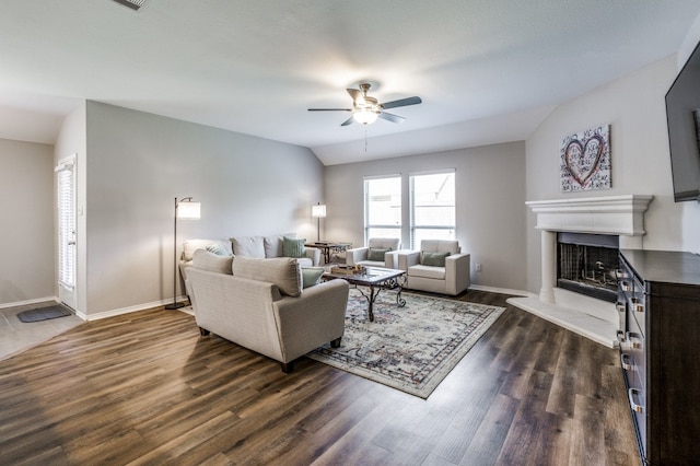 living room featuring dark wood-type flooring, ceiling fan, and vaulted ceiling