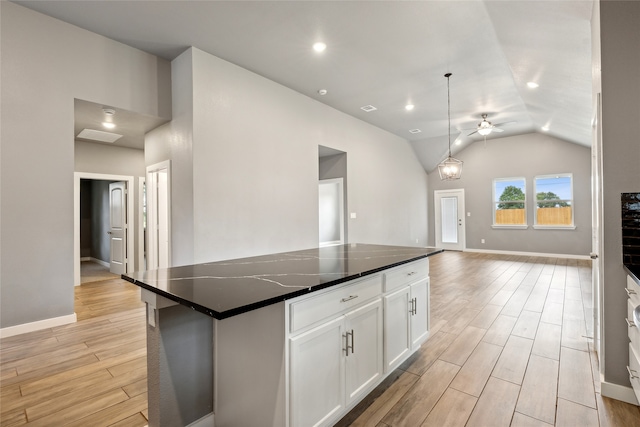 kitchen featuring vaulted ceiling, light wood-type flooring, white cabinetry, pendant lighting, and a kitchen island