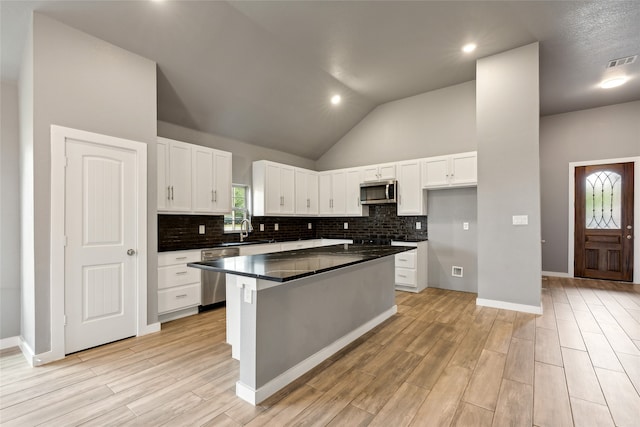 kitchen featuring a wealth of natural light, stainless steel appliances, and white cabinetry