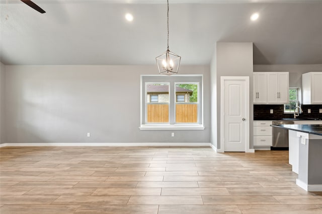 kitchen featuring ceiling fan with notable chandelier, dishwasher, pendant lighting, light hardwood / wood-style flooring, and white cabinets