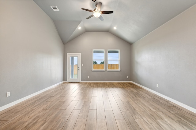 empty room featuring ceiling fan, light wood-type flooring, and vaulted ceiling