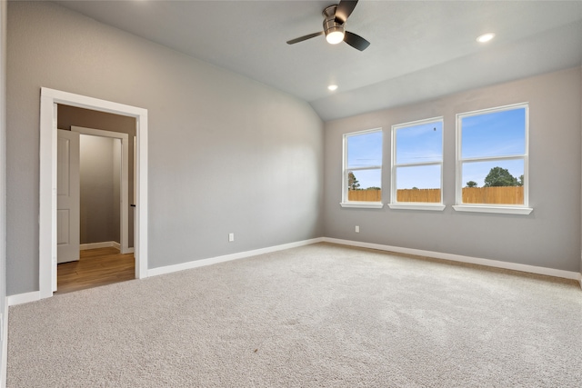 empty room featuring vaulted ceiling, ceiling fan, and carpet