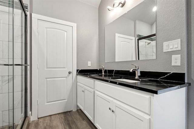 bathroom with hardwood / wood-style floors, an enclosed shower, and vanity