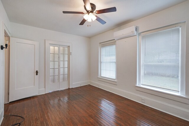 unfurnished bedroom featuring dark wood-type flooring, a wall unit AC, and ceiling fan