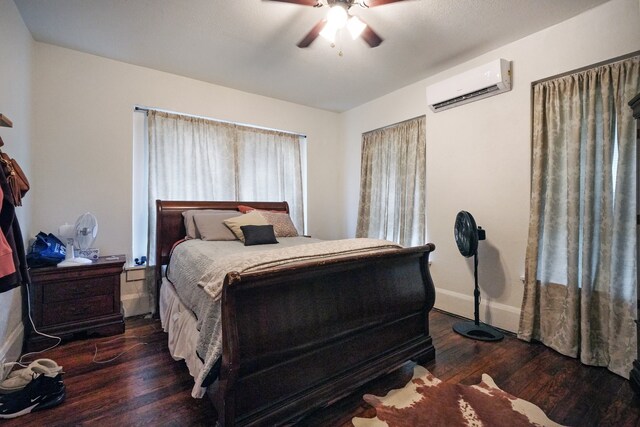 bedroom with ceiling fan, dark hardwood / wood-style floors, and a wall mounted air conditioner