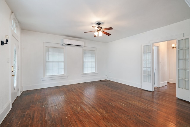 empty room with dark hardwood / wood-style flooring, an AC wall unit, and ceiling fan