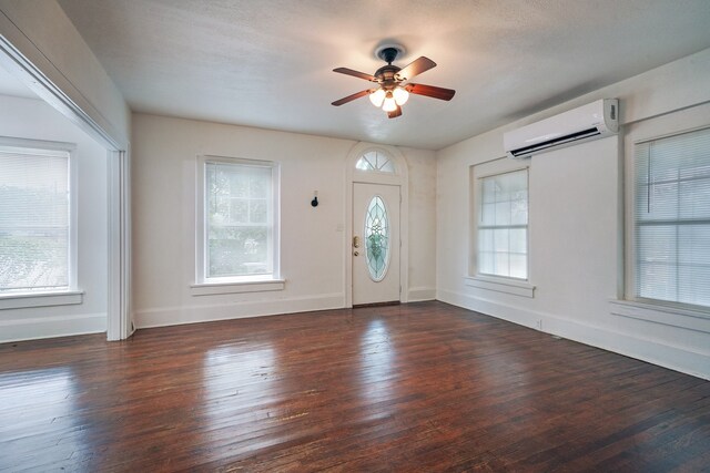 entryway featuring a healthy amount of sunlight, ceiling fan, dark hardwood / wood-style flooring, and a wall mounted AC