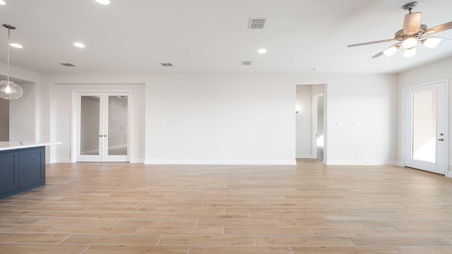 unfurnished living room with ceiling fan and french doors