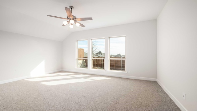 carpeted spare room with vaulted ceiling and ceiling fan