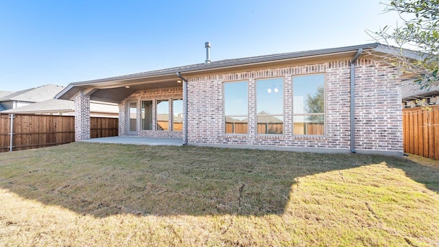 rear view of house featuring a lawn and a patio area