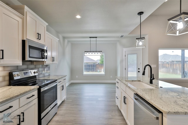 kitchen featuring white cabinetry, an island with sink, stainless steel appliances, and sink