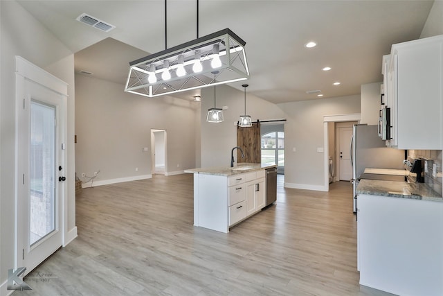 kitchen featuring white cabinetry, a healthy amount of sunlight, sink, and light hardwood / wood-style floors