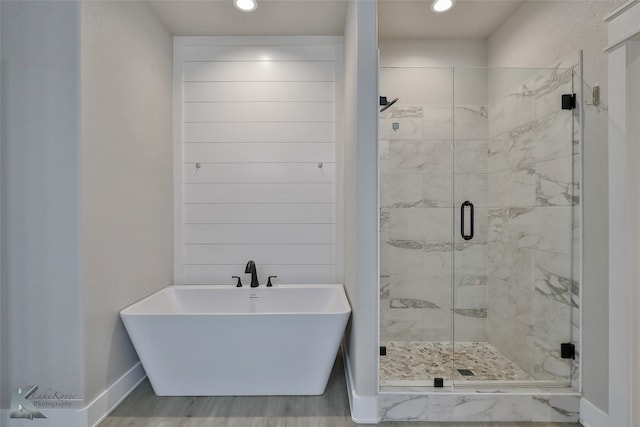 bathroom featuring separate shower and tub and wood-type flooring