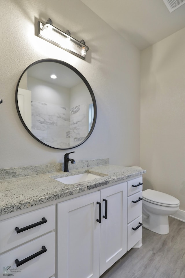 bathroom featuring vanity, toilet, and hardwood / wood-style flooring