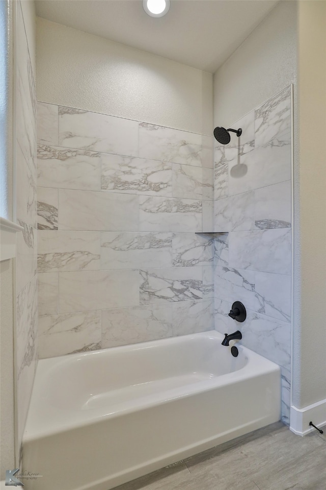 bathroom with hardwood / wood-style floors and tiled shower / bath combo