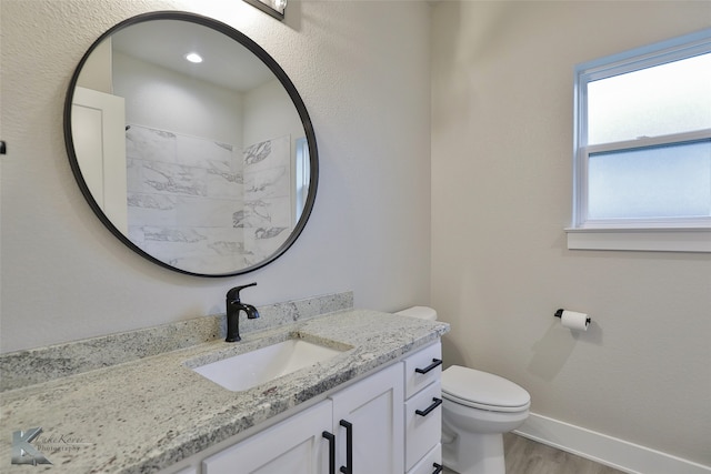 bathroom with vanity, toilet, and hardwood / wood-style flooring