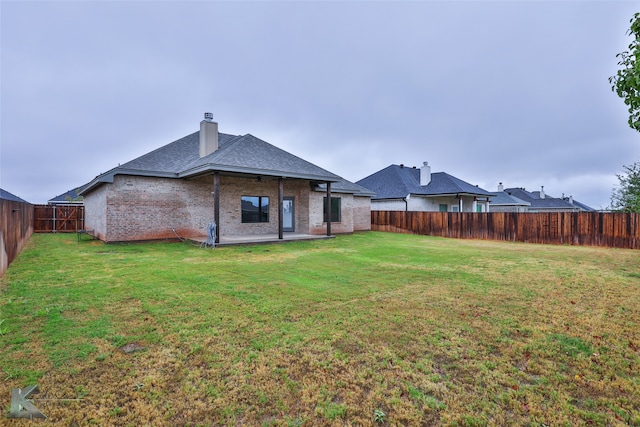 rear view of house with a yard and a patio