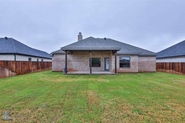 rear view of house featuring a patio area and a yard