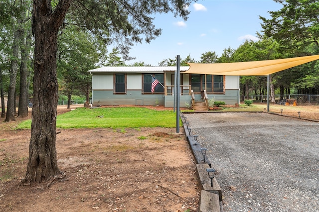 ranch-style home featuring a carport and a front lawn