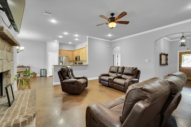 living room with a fireplace, crown molding, and ceiling fan with notable chandelier