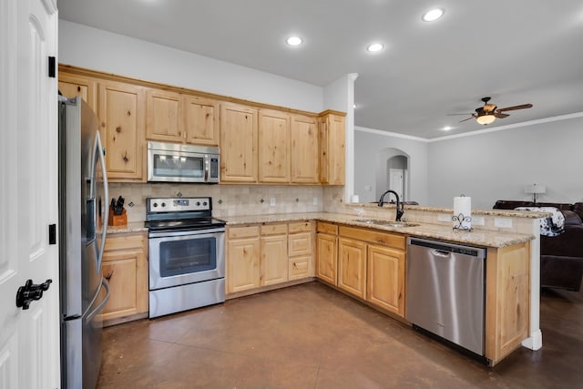 kitchen featuring light stone countertops, stainless steel appliances, sink, kitchen peninsula, and ceiling fan