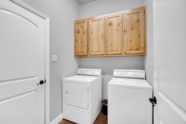 laundry room featuring washing machine and clothes dryer and cabinets